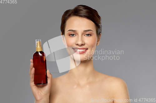 Image of beautiful young woman with sun protective oil