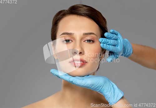 Image of beautiful young woman face and hand in gloves