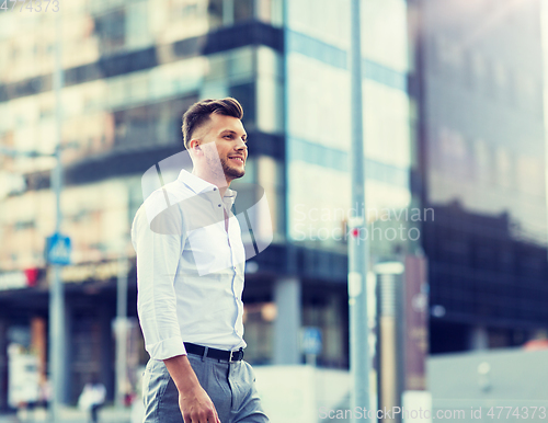 Image of young man walking along city street