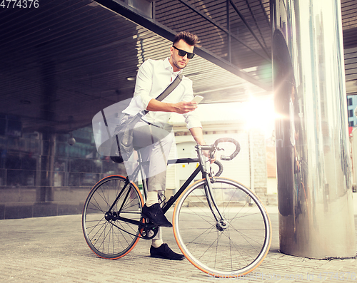 Image of man with bicycle and smartphone on city street