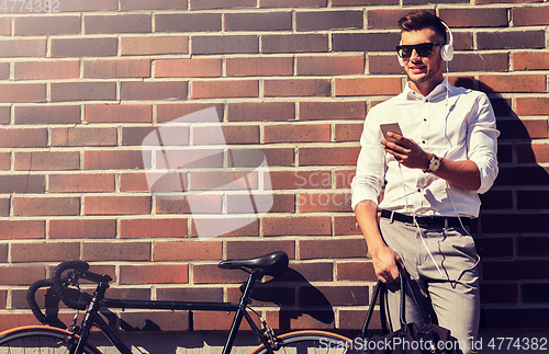 Image of man with headphones, smartphone and bicycle
