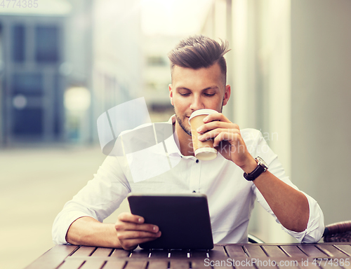 Image of man with tablet pc and coffee at city cafe