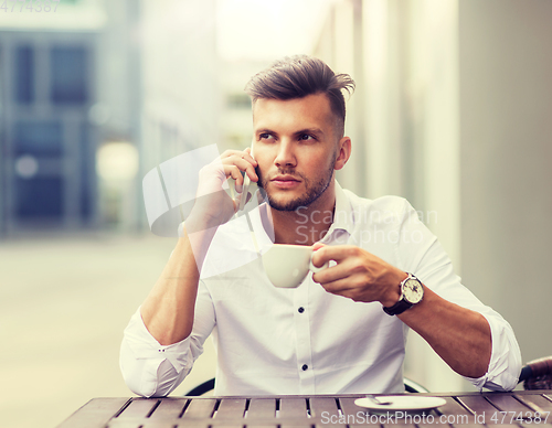 Image of man with coffee calling on smartphone at city cafe