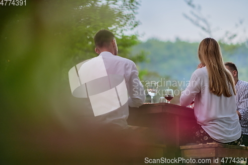 Image of friends having picnic french dinner party outdoor during summer holiday