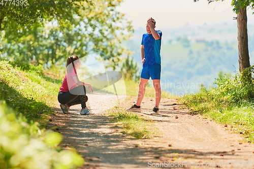 Image of couple enjoying in a healthy lifestyle while jogging on a country road