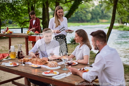 Image of friends having picnic french dinner party outdoor during summer holiday