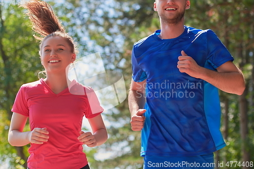 Image of couple enjoying in a healthy lifestyle while jogging on a country road