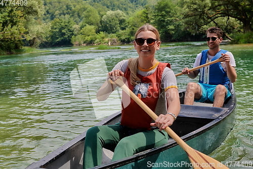 Image of friends are canoeing in a wild river