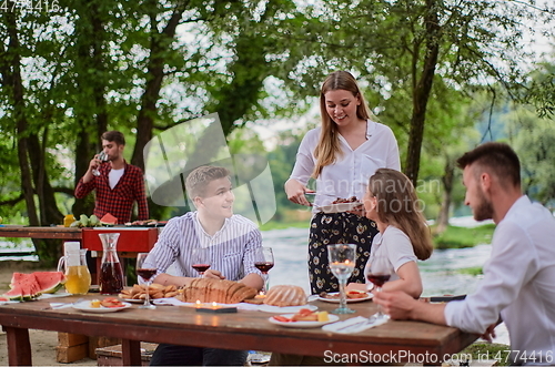 Image of friends having picnic french dinner party outdoor during summer holiday