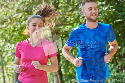 Image of couple enjoying in a healthy lifestyle while jogging on a country road