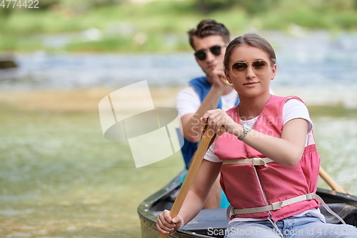 Image of friends are canoeing in a wild river