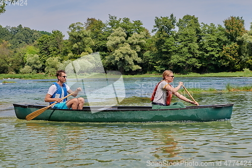 Image of friends are canoeing in a wild river