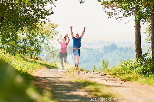 Image of couple enjoying in a healthy lifestyle while jogging on a country road