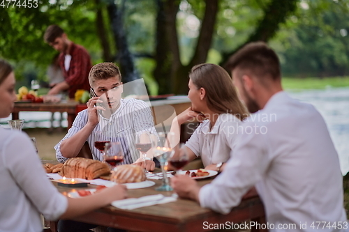 Image of friends having picnic french dinner party outdoor during summer holiday