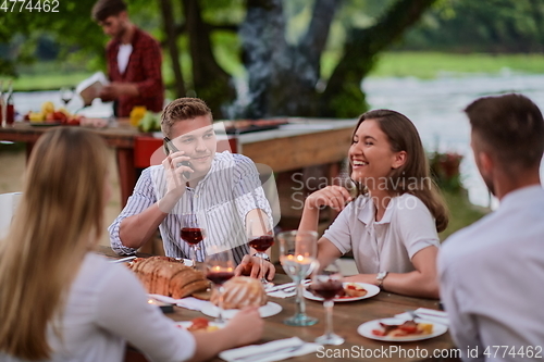 Image of friends having picnic french dinner party outdoor during summer holiday