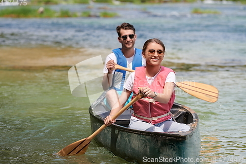 Image of friends are canoeing in a wild river