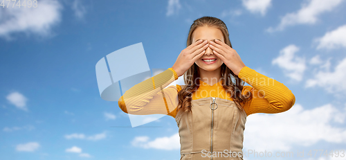 Image of smiling teenage girl closing her eyes over sky