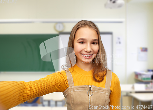 Image of happy student girl taking selfie at school