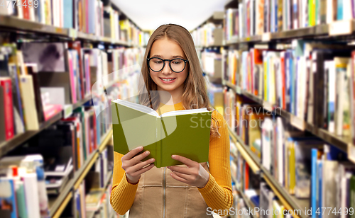 Image of student girl in glasses reading book at library