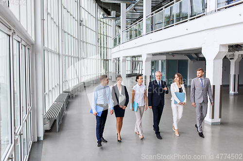 Image of business people walking along office building