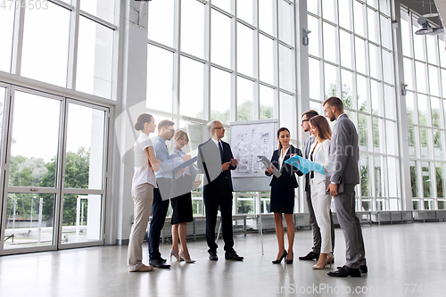 Image of business team with scheme on flip chart at office