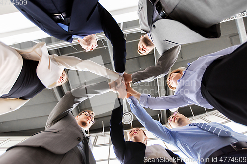 Image of business people making high five at office