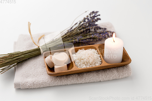 Image of sea salt, soap, candle and lavender on bath towel