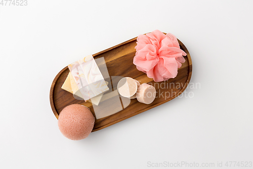 Image of crafted soap, sponge and wisp on wooden tray