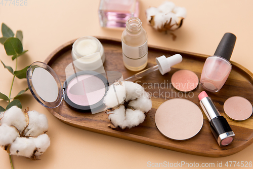 Image of makeup, perfume and cosmetics on wooden tray