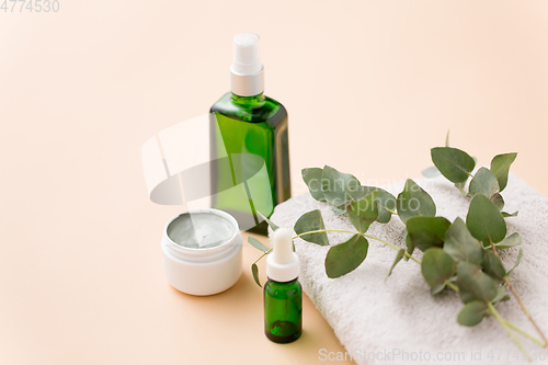 Image of serum, clay mask, oil and eucalyptus on bath towel