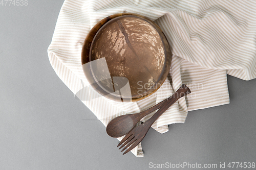 Image of close up of coconut bowl, wooden spoon and fork