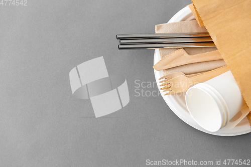 Image of wooden forks, knives and paper cups on plate