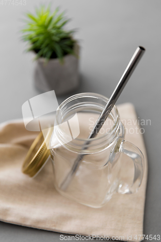 Image of empty glass mug of with reusable metallic straw