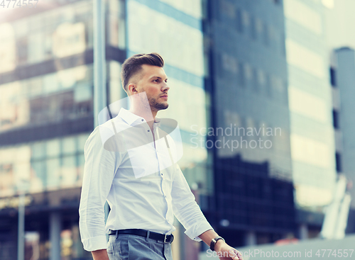 Image of young man walking along city street