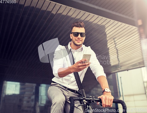 Image of man with bicycle and smartphone on city street