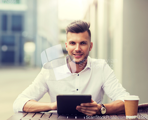 Image of man with tablet pc and coffee at city cafe