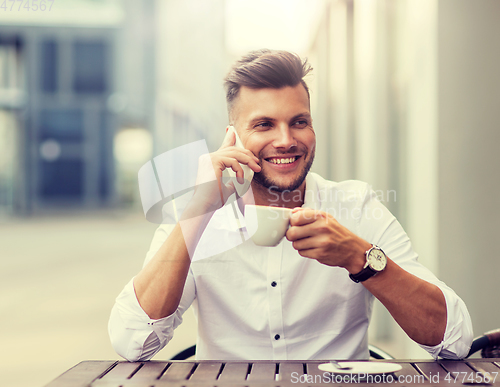 Image of man with coffee calling on smartphone at city cafe