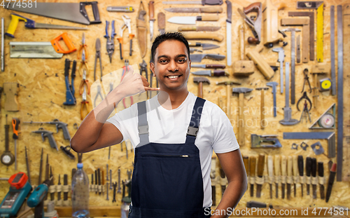 Image of happy worker or builder making phone call gesture