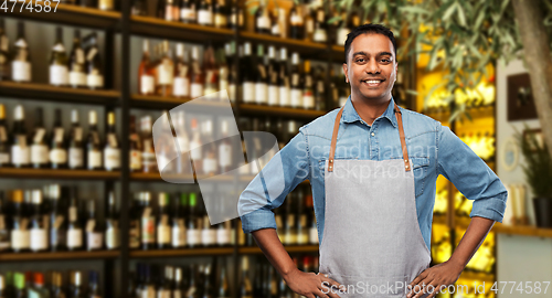 Image of smiling indian barman or waiter at wine bar