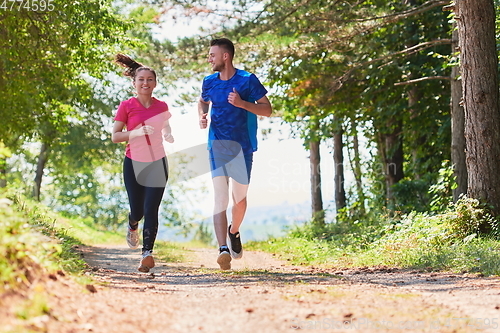 Image of couple enjoying in a healthy lifestyle while jogging on a country road