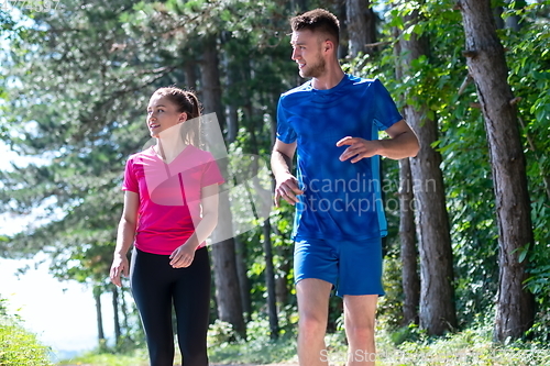 Image of couple enjoying in a healthy lifestyle while jogging on a country road