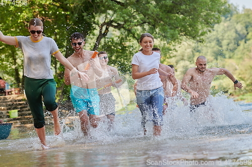 Image of group of happy friends having fun on river