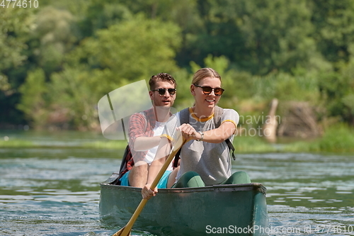 Image of friends are canoeing in a wild river