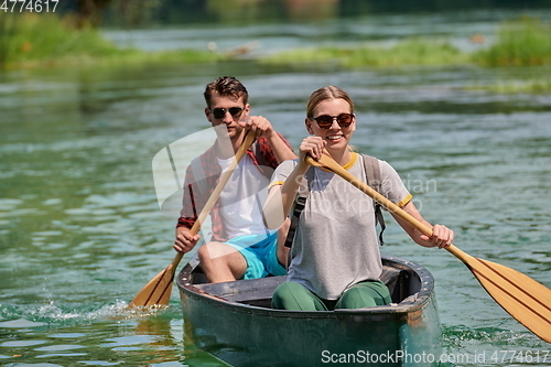 Image of friends are canoeing in a wild river