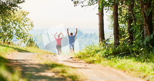 Image of couple enjoying in a healthy lifestyle while jogging on a country road