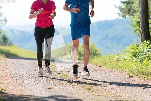 Image of couple enjoying in a healthy lifestyle while jogging on a country road