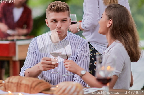 Image of friends having picnic french dinner party outdoor during summer holiday