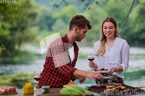 Image of friends having picnic french dinner party outdoor during summer holiday