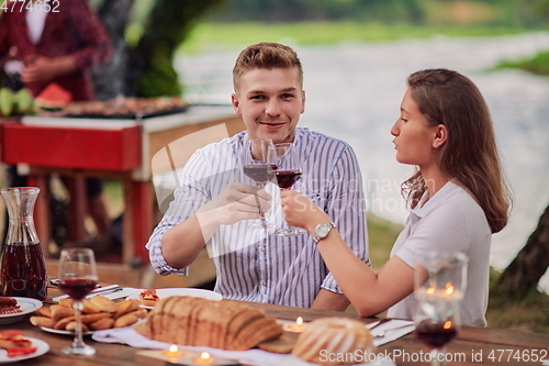 Image of friends having picnic french dinner party outdoor during summer holiday