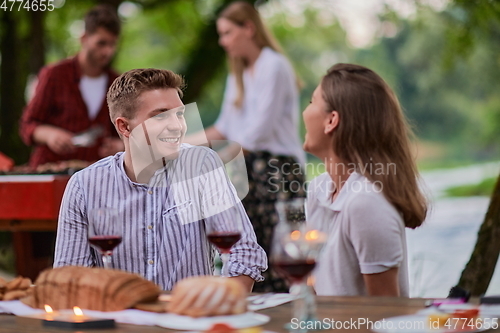 Image of friends having picnic french dinner party outdoor during summer holiday